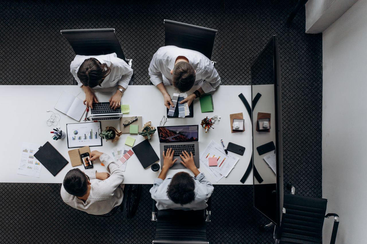 About Teamwork in modern office with laptops, charts, and electronic devices from above.